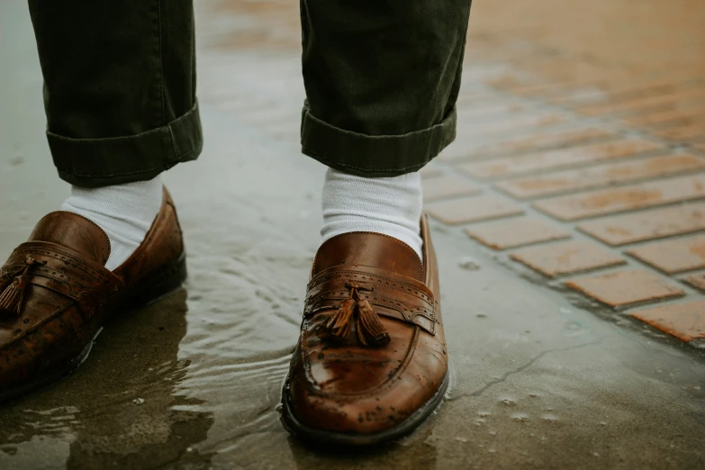 a close up po of a person wearing brown shoes with a white sock