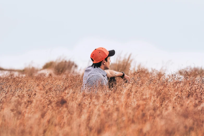 a man is walking through the tall grass