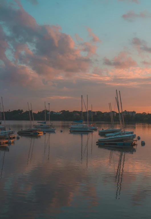 boats are on the water as the sun sets