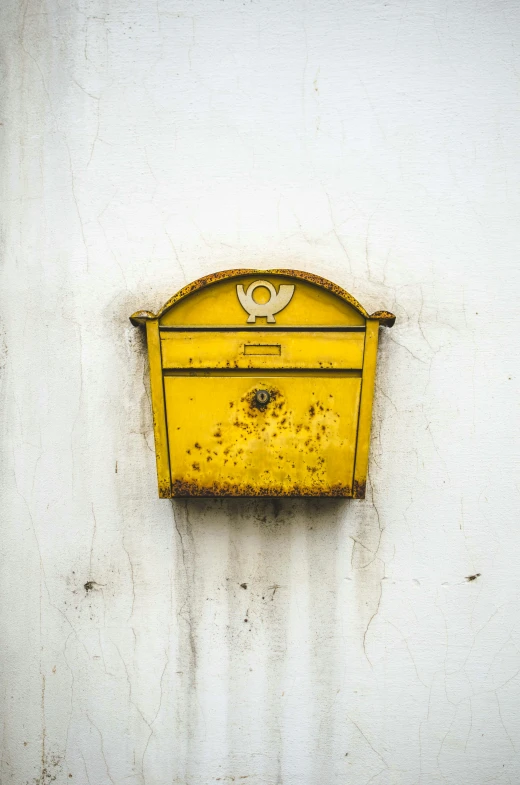 there is an old fashioned mailbox painted yellow