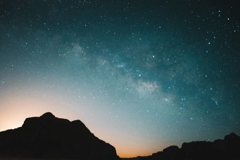 a mountain under a night sky with stars above