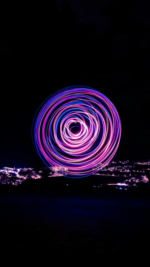 a ferris wheel is illuminated at night in the distance