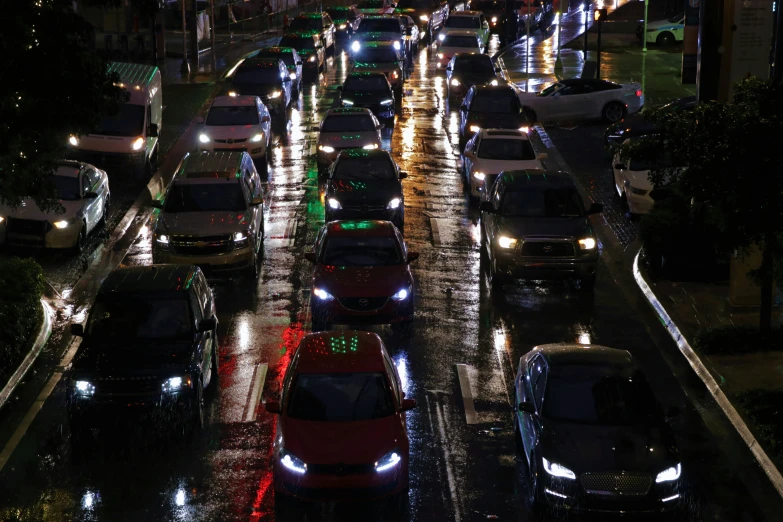 traffic is lined up on a busy city street at night