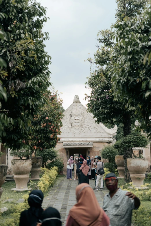 people walk up an ornate walkway that leads into a building