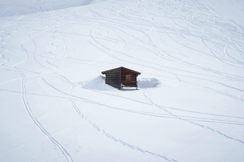 an outhouse is standing in the middle of snow