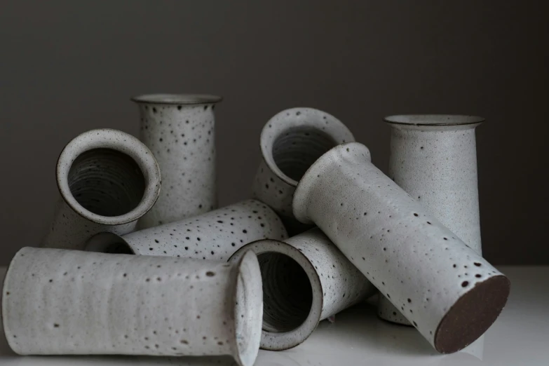 an assortment of cement like vases arranged on a counter