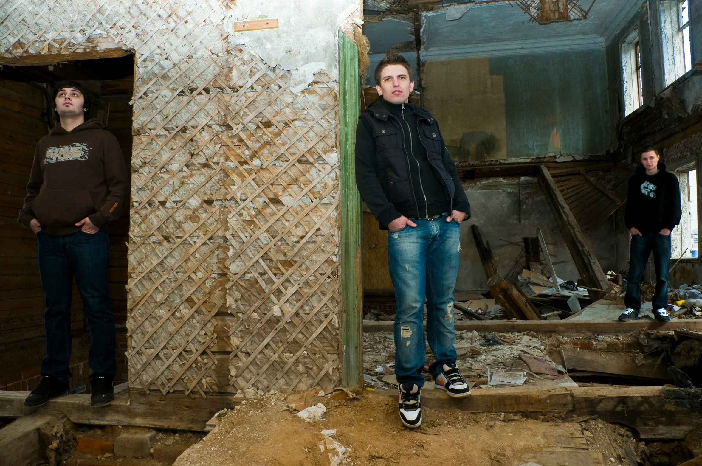 three people standing next to each other in an abandoned building