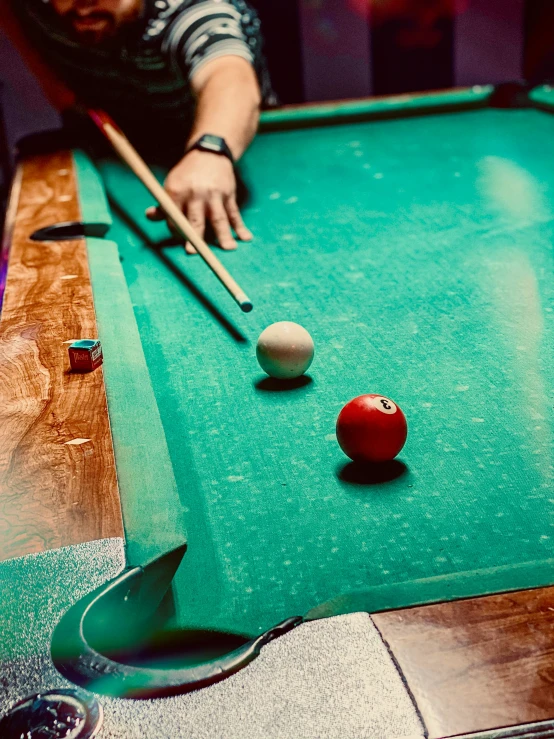 man with the billiard's hand about to hit the ball