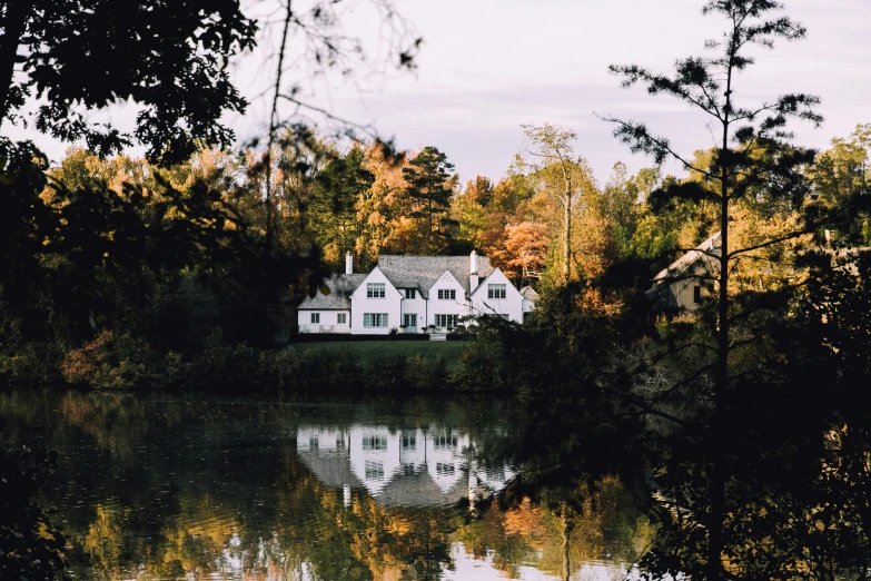 a white house on a river surrounded by trees