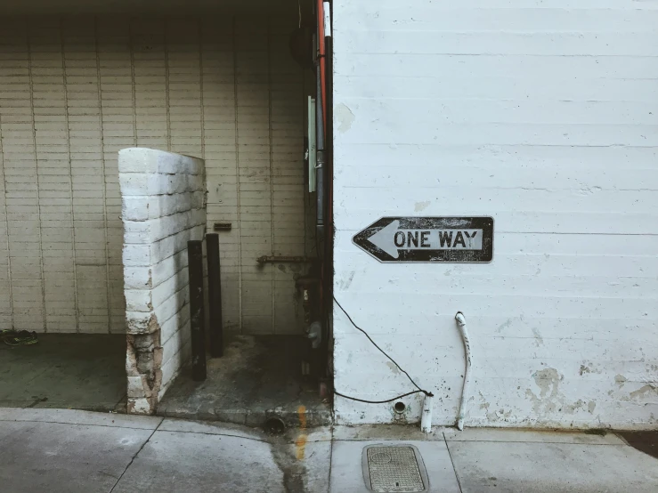 the one way sign is painted on the side of a building
