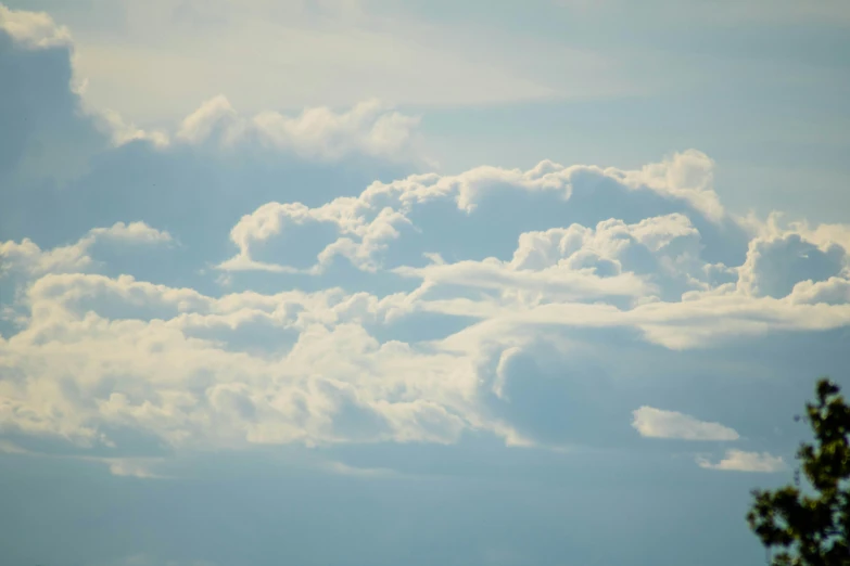 a plane flying high into the cloudy sky