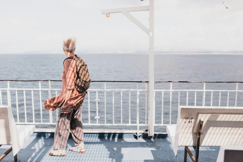 an elderly woman standing on a cruise ship deck