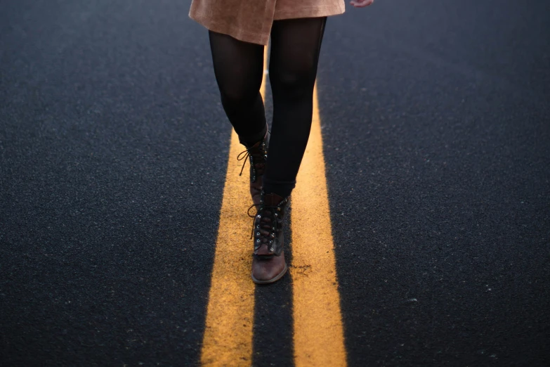 a woman with long brown hair and glasses walking on the street
