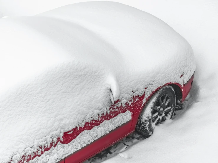 a car covered in snow on a snowy day