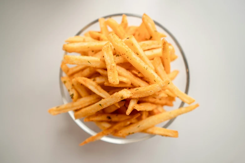 some fried french fries in a bowl on a table