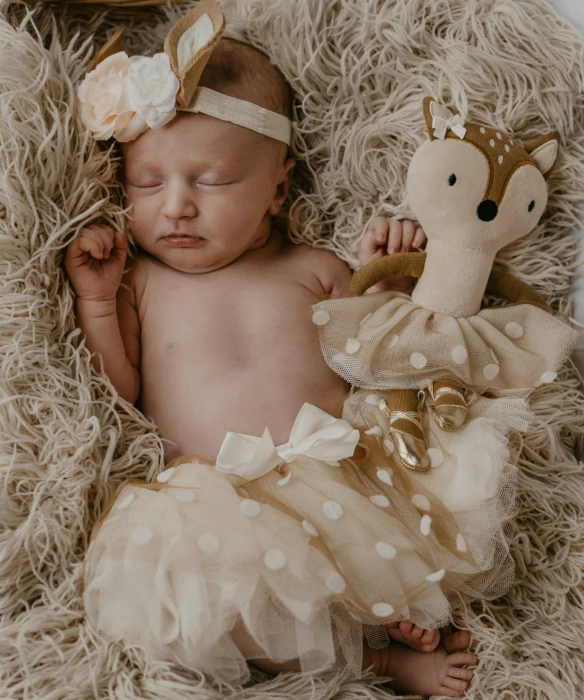 the newborn is dressed in a golden tutu and white lace, as it sleeps