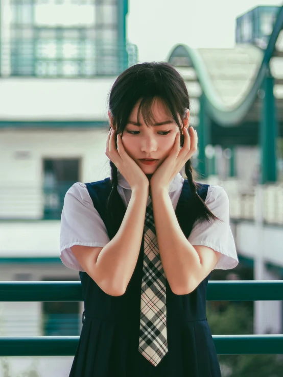 the young woman is holding her hands near her face