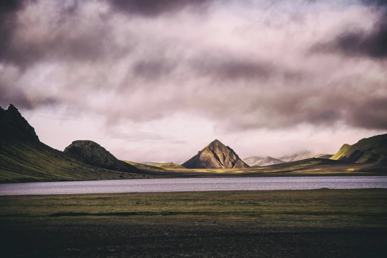 a group of mountains under a cloudy sky