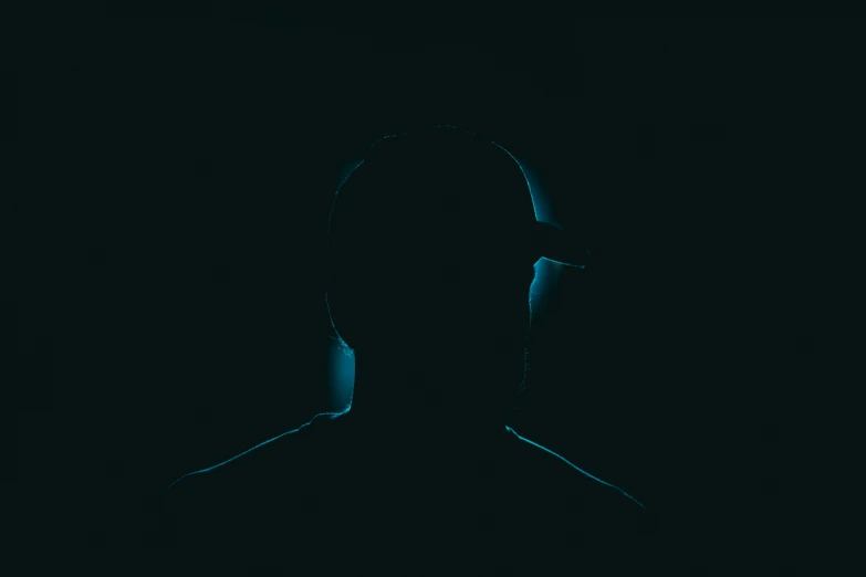 a person standing in the dark in headphones