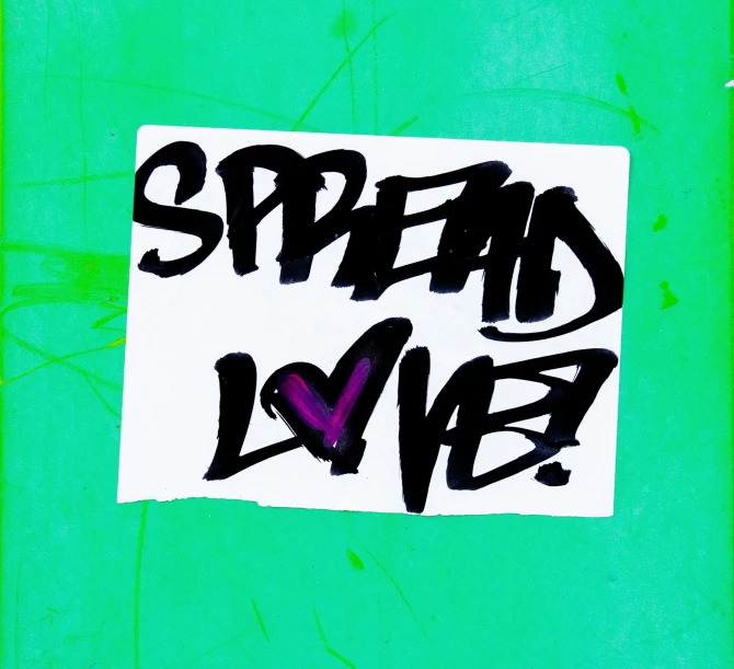 graffiti on green wall reading spread love