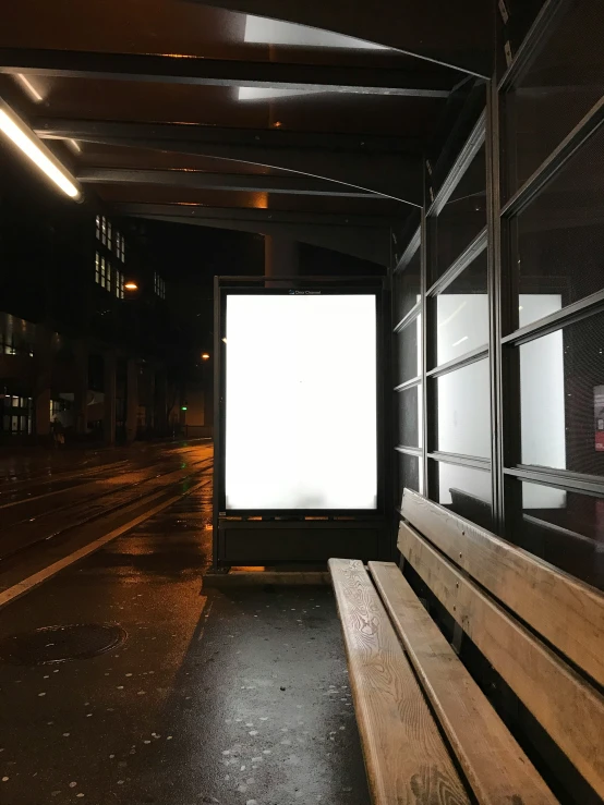 a large white sign sitting on the side of a wooden bench