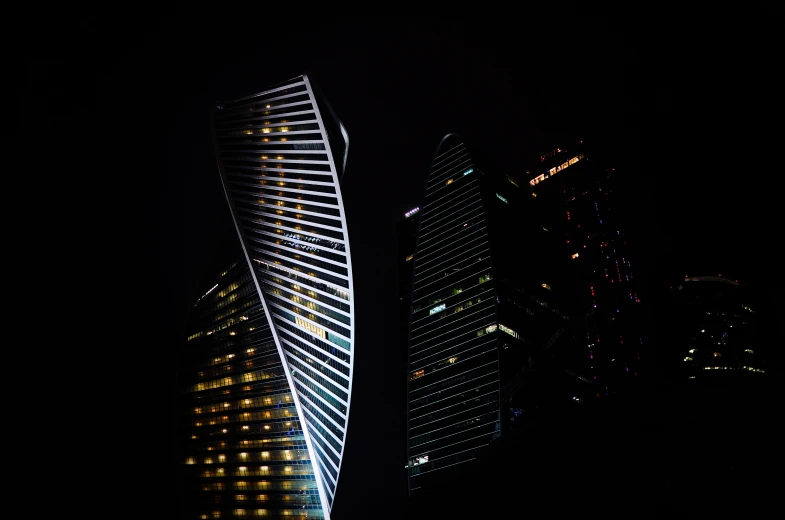 two very tall buildings lit up at night