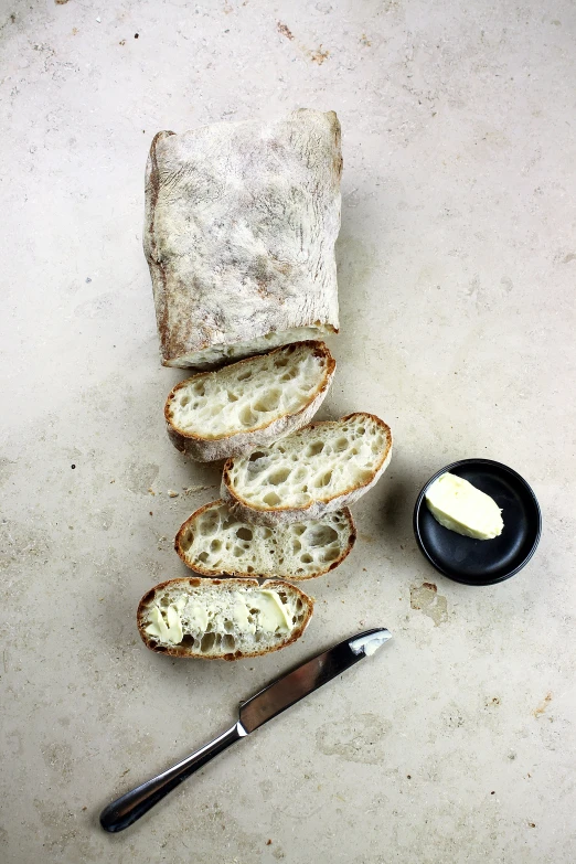 a loaf of bread, knife and a bowl with er