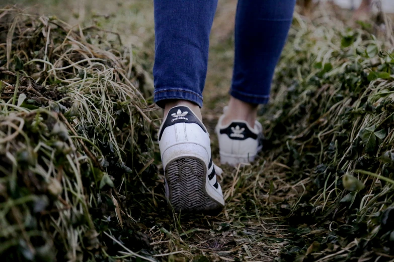 someone walking through grass with their shoes on