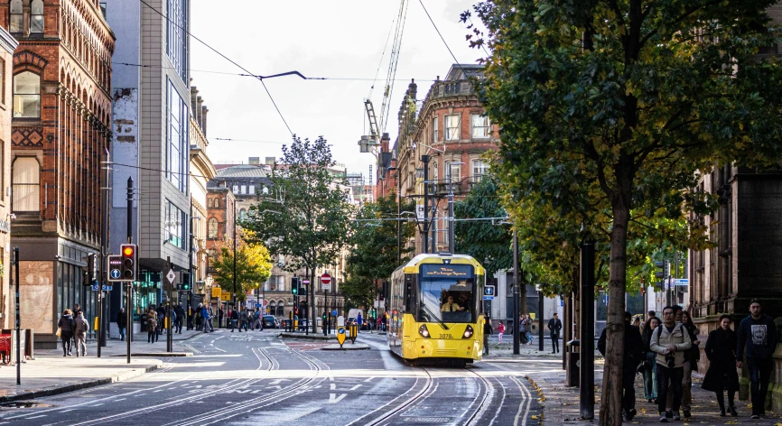 a city street with a yellow and white bus on it