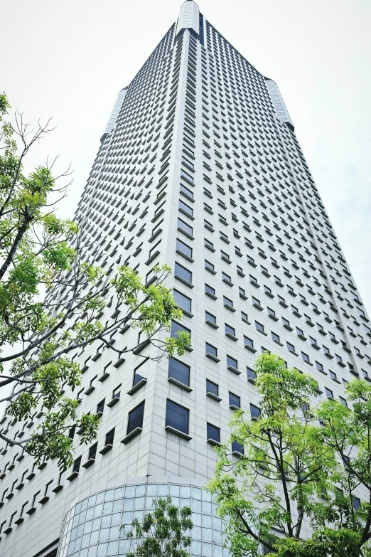 a very tall gray building sitting among trees