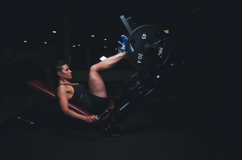 a girl is doing leg presses on an exercise machine