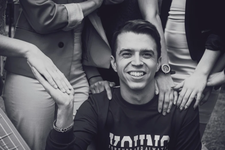 a man surrounded by other people smiling for a camera