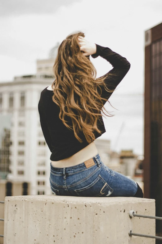 a woman with long hair is sitting and posing