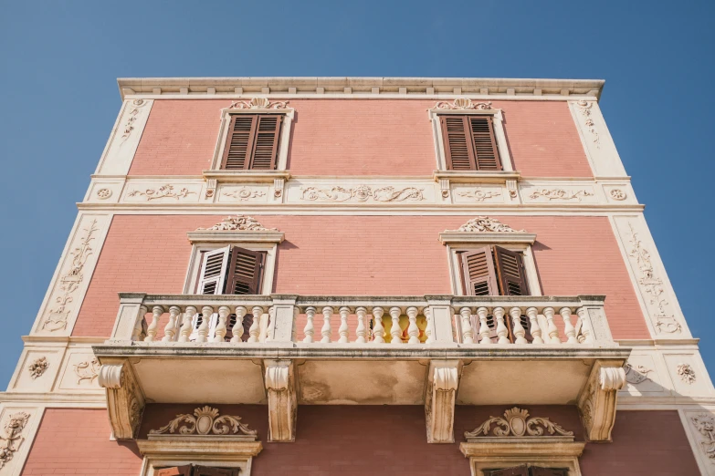 an old pink building with balcony and balconies