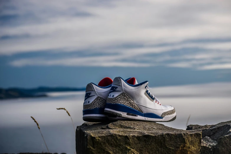 the shoe is on the ledge next to a body of water