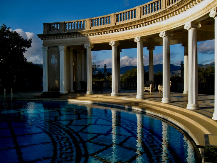 a pool with some pillars by the side of it