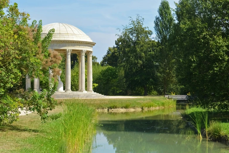 there is a gazebo by the lake in the park