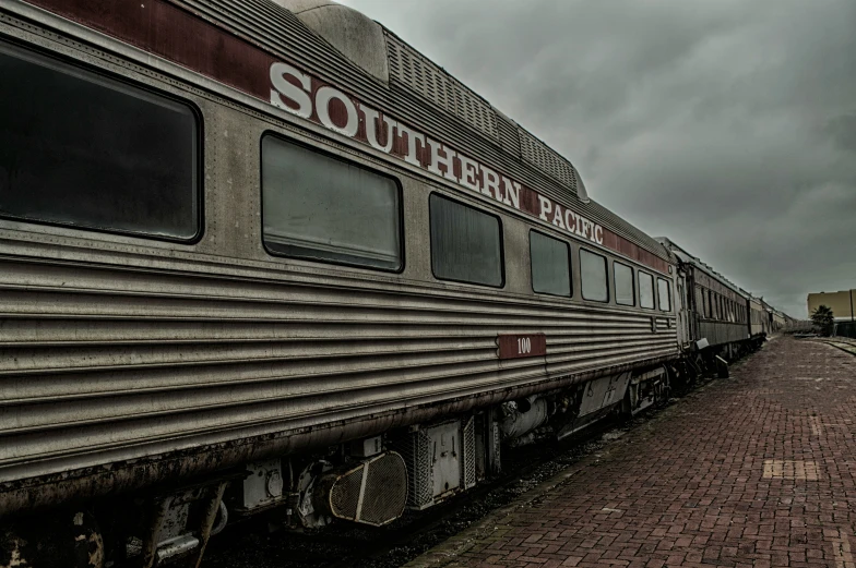 the old railroad train is parked in a station