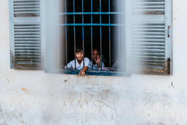 a group of people standing behind bars on a building