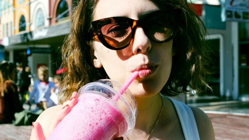 a close up of a person with sunglasses and a drink