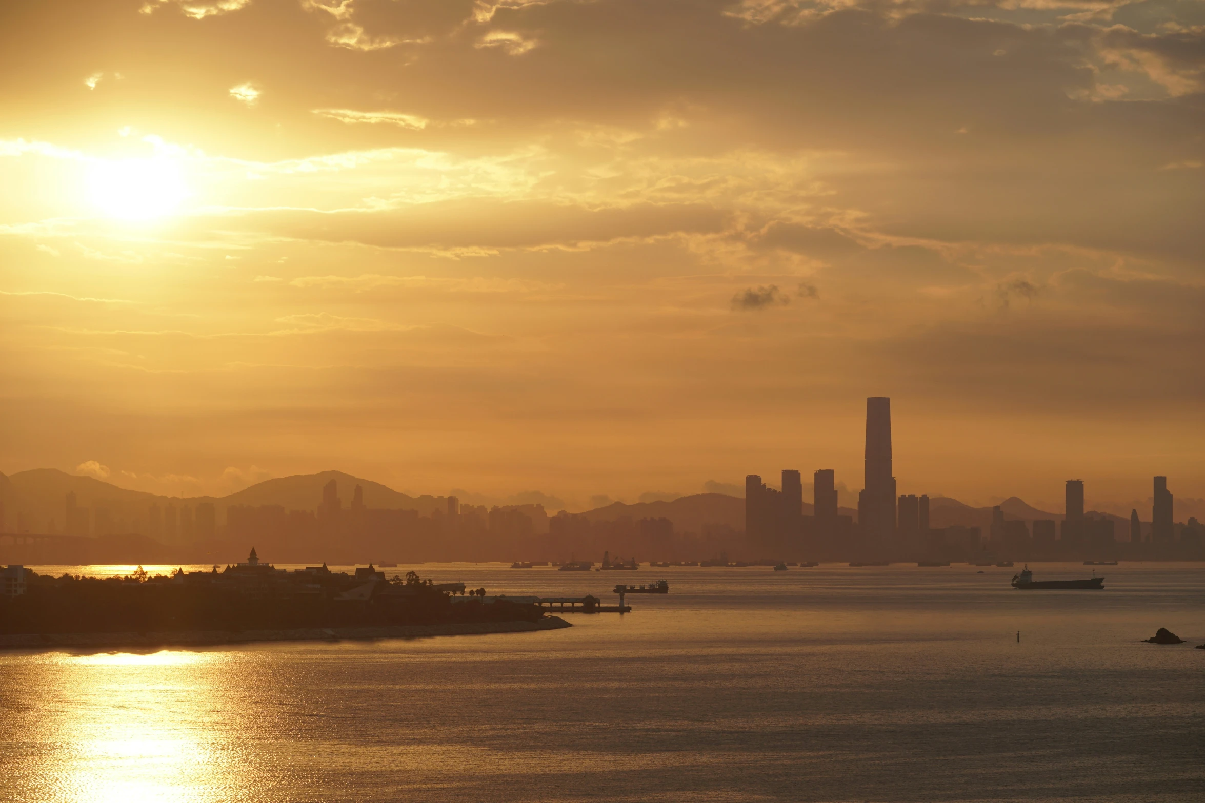 a sunset over a city and a lake