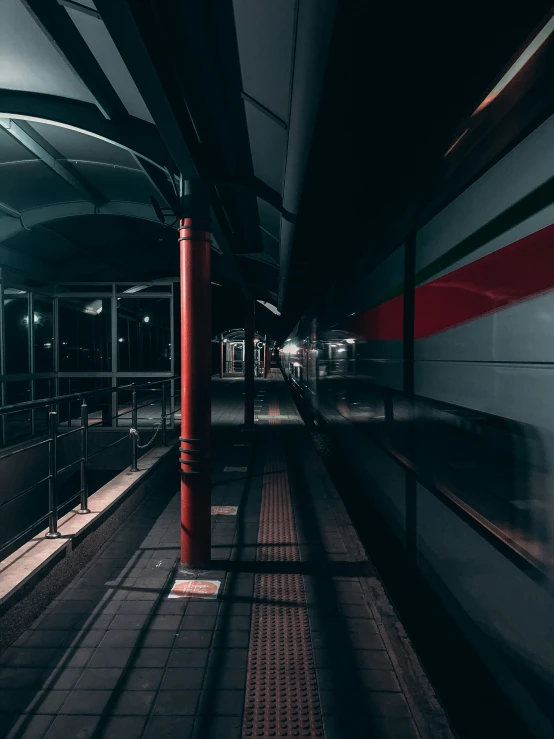 a train traveling under an overpass at night