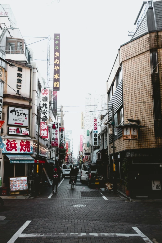 an urban city street with asian writing written above buildings