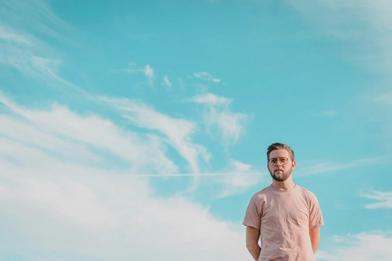 man standing alone in the sun wearing glasses