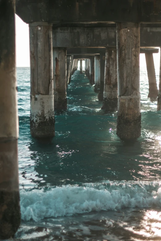the underside view of a pier stretching into the ocean