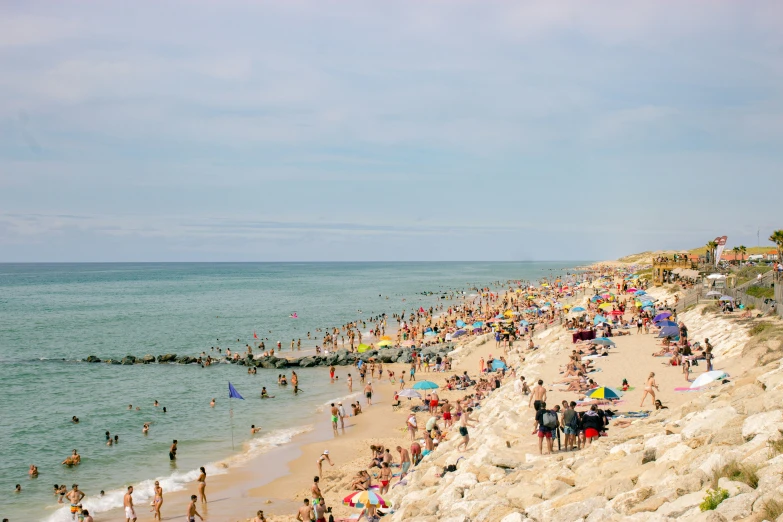 several people are on the beach and swimming