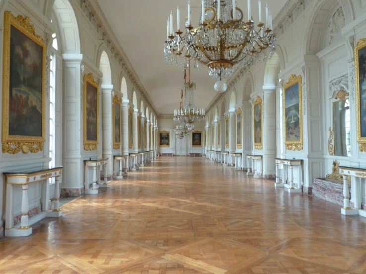 a hall with white walls and lots of gold