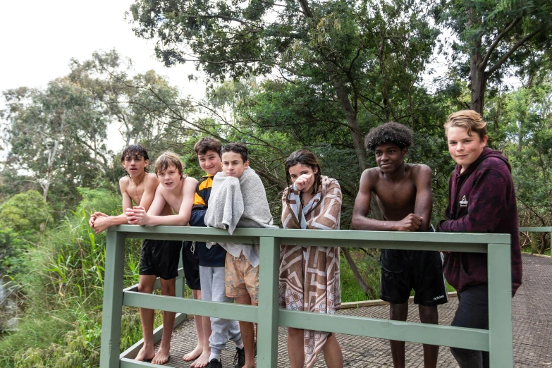 five boys standing on the wooden bridge together