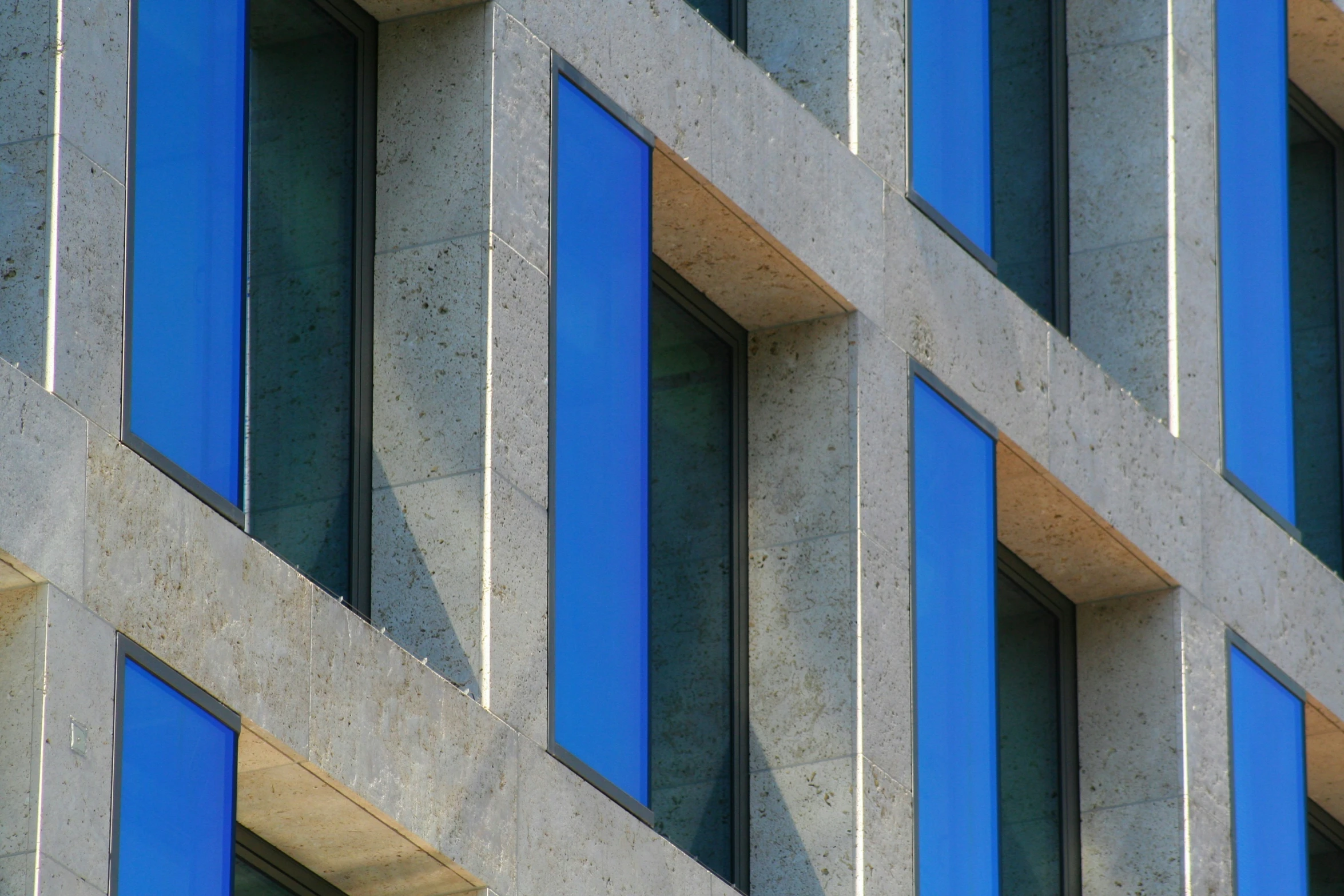 a large building with windows made of cement and blue frames