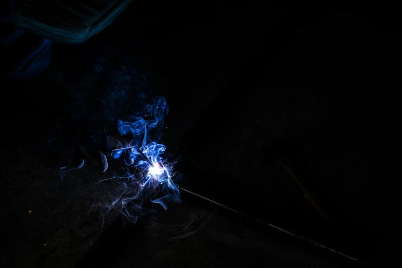 a sparkler with blue fire and black background